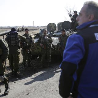 Des observateurs de l'OSCE devant des armes ukrainiennes à Donetsk, le 27 février 2015.