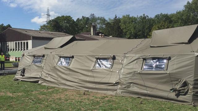 Tentes militaires installées à Lyss, dans le canton de Berne. [Julien Hostettler]