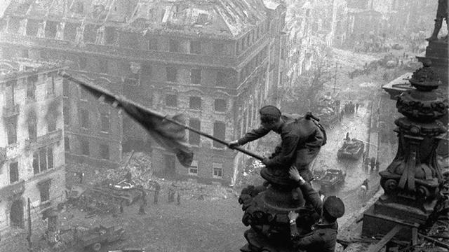 Le drapeau soviétique hissé sur une ruine de Berlin, mai 1945. [Itar-Tass/AP/Keystone - Yevgeny Khaldei]