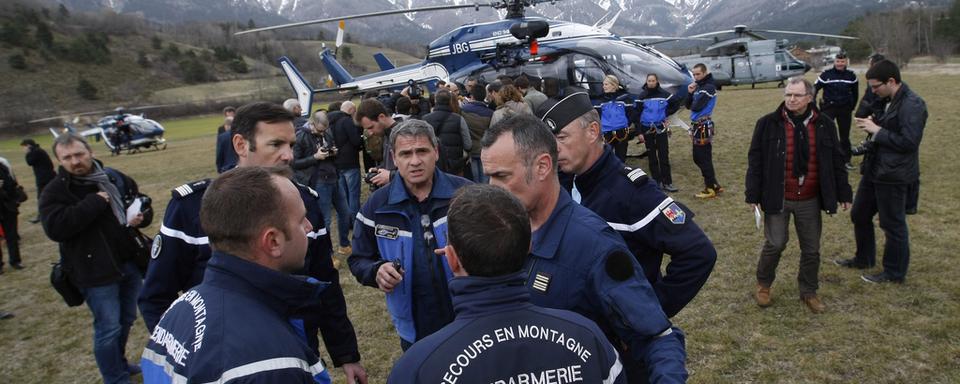 Les secours et membres de la gendarmerie en pleine organisation pour se rendre sur les lieux du crash. [AP Photo/Keystone - Claude Paris]