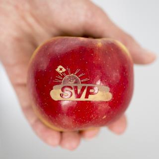 Le logo de l'UDC gravé sur une pomme. [Keystone - Gian Ehrenzeller]