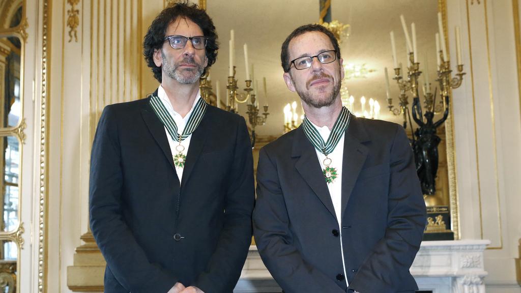 Joel Coen (gauche) et son frère Ethan, lors d'une cérémonie de remise de la médaille de Commandeur des Arts et Lettres au ministère français de la Culture, en octobre 2013.