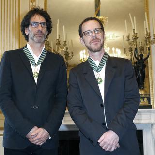 Joel Coen (gauche) et son frère Ethan, lors d'une cérémonie de remise de la médaille de Commandeur des Arts et Lettres au ministère français de la Culture, en octobre 2013.