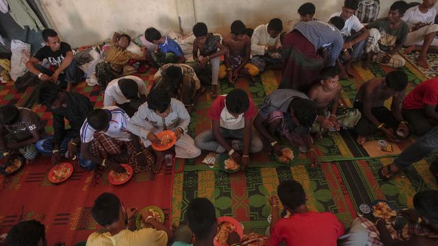 Des migrants birmans au cours d'un repas dans le camp de réfugiés de Kuala Langsa, en Indonésie. [AFP - Y.T HARYONO / Anadolu Agency]