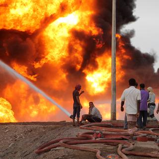 Des Yéménites tentent d'éteindre le feu consécutif au bombardement d'une raffinerie par les rebelles houthis. [AFP - Saleh Al-Obeidi]