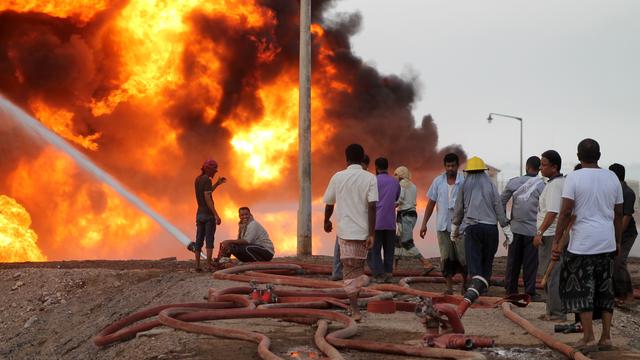 Des Yéménites tentent d'éteindre le feu consécutif au bombardement d'une raffinerie par les rebelles houthis. [AFP - Saleh Al-Obeidi]