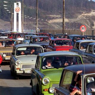 Des Trabant passant de l'Est à l'Ouest le 11.11.1989, symbole de la Réunification allemande. [EPA/Keystone - Kai-Uwe Wärner]