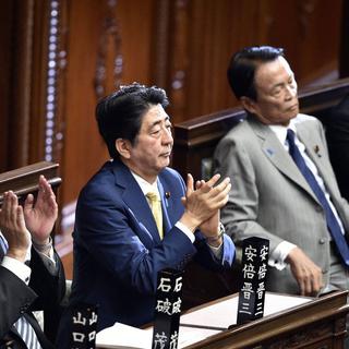 Shinzo Abe applaudit le vote du parlement japonais jeudi à Tokyo. [EPA/Keystone - Franck Robichon]