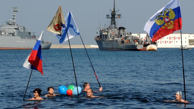 Des pro-Russes se baignant dans les eaux froides du port de Sébastopol le 15 mars 2014, un jour avant le référendum sur le rattachement de la Crimée à la Russie. [AFP - Viktor Drachev]