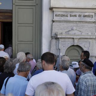 Les Grecs étaient en file d'attente devant les banques au moment de leur réouverture lundi matin. [Keystone - Thanassis Stavrakis]
