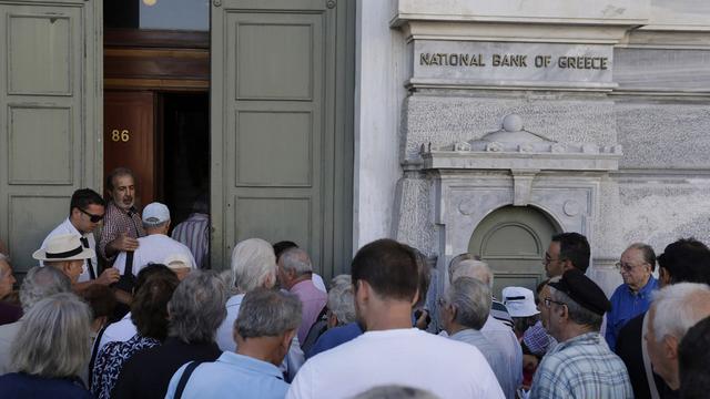 Les Grecs étaient en file d'attente devant les banques au moment de leur réouverture lundi matin. [Keystone - Thanassis Stavrakis]