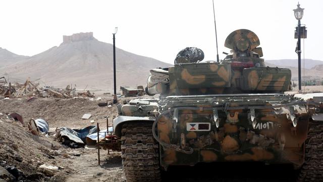 Tank de l'armée syrienne positionné en bordure de la ville de Palmyre. [EPA/Keystone]