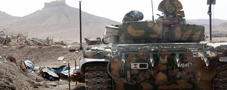 Tank de l'armée syrienne positionné en bordure de la ville de Palmyre. [EPA/Keystone]