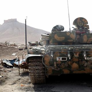Tank de l'armée syrienne positionné en bordure de la ville de Palmyre. [EPA/Keystone]