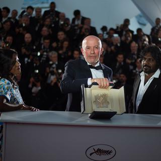 Jacques Audiard a reçu la Palme d'or à Cannes pour son film "Dheepan". Il pose avec les acteurs sri lankais Kalieaswari Srinivasan (à gauche) et Jesuthasan Antonythasan. [AFP - Bertrand Langlois]