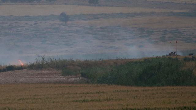 L'armée turque postée (tank à droite) à la frontière syrienne jeudi. [Keystone/AP Photo - Emrah Gurel]