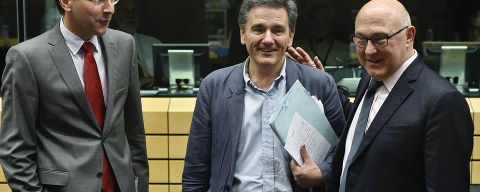 Le nouveau ministre grec des Finances Euclide Tsakalotos entouré par ses homologues néerlandais Jeroen Dijsselbloem, président de l'Eurogroupe, et français Michel Sapin. [John Thys]