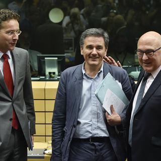 Le nouveau ministre grec des Finances Euclide Tsakalotos entouré par ses homologues néerlandais Jeroen Dijsselbloem, président de l'Eurogroupe, et français Michel Sapin. [John Thys]