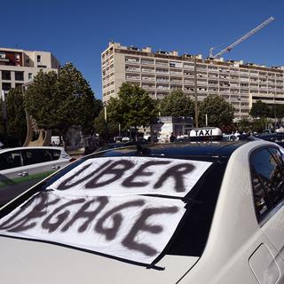 Les taxis se liguent contre Uber. [AFP - Anne-Christine Poujoulat]