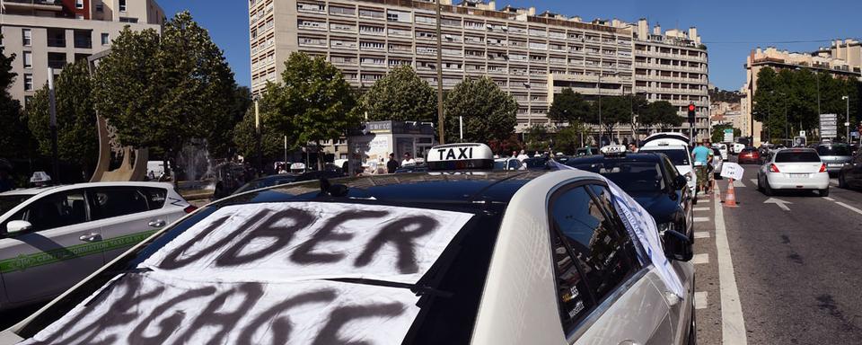 Les taxis se liguent contre Uber. [AFP - Anne-Christine Poujoulat]