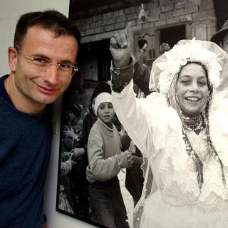 Le photographe lausannois Yves Leresche pose devant une de ses images en 2002 au Musée de l'Elysee à Lausanne. [Keystone - Fabrice Coffrini]