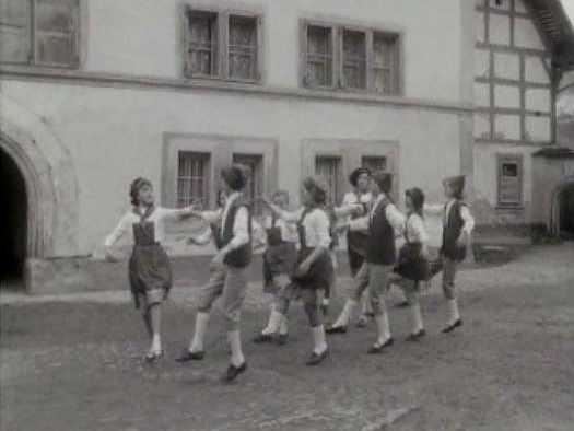 Groupe d'enfants dansant dans rue de Gruyères. [RTS]