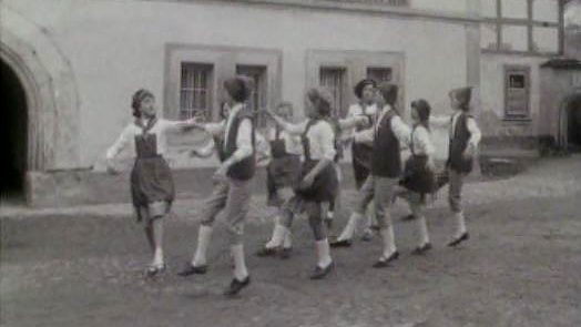 Groupe d'enfants dansant dans rue de Gruyères. [RTS]