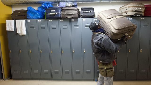 Un requérant range ses affaires dans le dortoir d'un centre d'hébergement situé dans un abri de la protection civile à Lausanne. [Keystone - Laurent Gillieron]