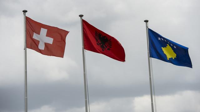 Les drapeaux de la Suisse, de l'Albanie et du Kosovo. [Keystone - Jean-Christophe Bott]