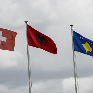 Les drapeaux de la Suisse, de l'Albanie et du Kosovo. [Keystone - Jean-Christophe Bott]