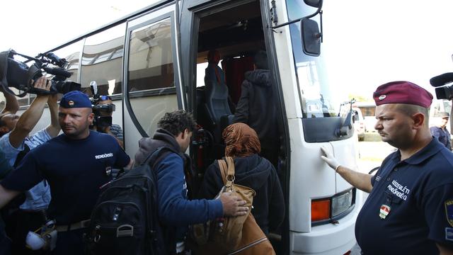 La police hongroise escorte des réfugiés dans des bus. [Leonhard Foeger]