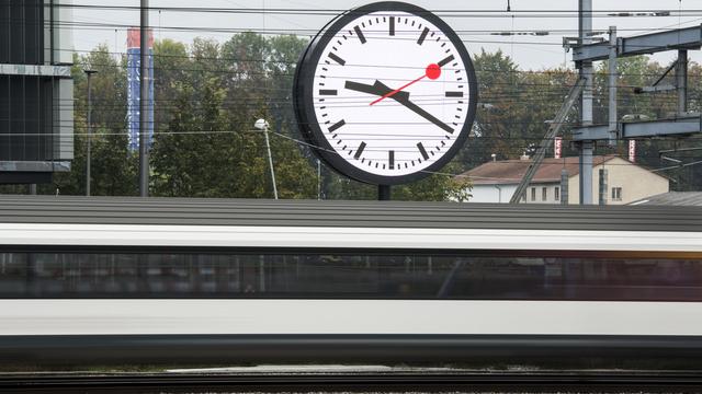 Un train passe devant l'horloge géante installée devant le nouveau quartier général des CFF à Berne.