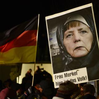 LA manifestation de Pegida du 12 janvier dernier à Dresde, avec une image d'Angela Merkel portnat le foulard. [AP Photo/Jens Meyer]