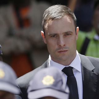 Oscar Pistorius escorté par des policiers, le 17 octobre 2014, alors qu'il quitte la Haute Cour de Pretoria. [Themba Hadebe]