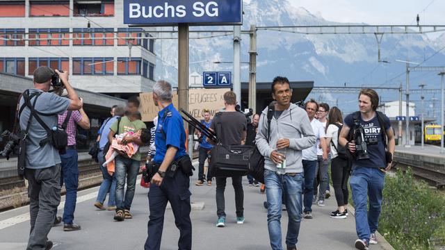 Policiers et médias attendaient l'arrivée des migrants par le train de nuit mardi matin 01.09.2015 à Buchs (SG). [Keystone - Dominic Steinmann]