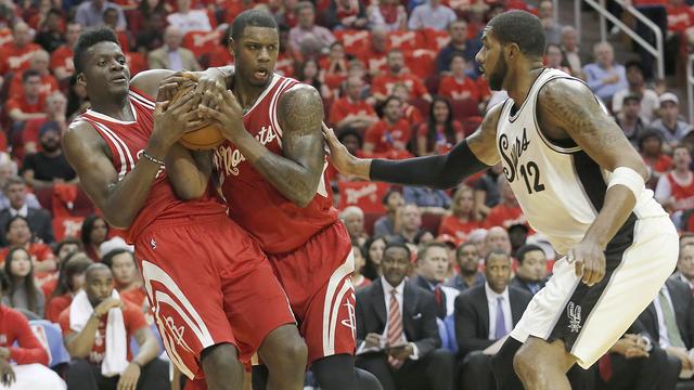 Clint Capela (à gauche) et Terrence Jones se disputent un rebond sous les yeux de LaMarcus Aldridge.