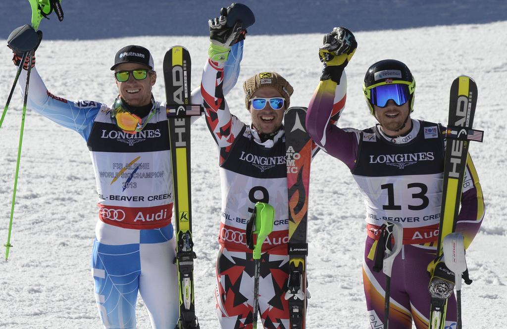 Ligety (à ga.) et Janrsud (à dr.) entourent le vainqueur. [KEYSTONE - Hans Klaus Techt]