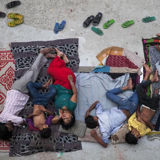 Une famille indienne dort sur le toit d'une habitation. [AP Photo/Keystone - Tsering Topgyal]