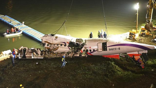 Le fuselage endommagé de l'avion est ramené sur le rivage par les équipes de secours. [AP/STR]