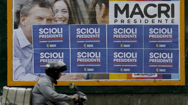 Une affiche appelant à voter Mauricio Macri, recouverte par celles de Daniel Scioli. [AP Photo/Natacha Pisarenko]