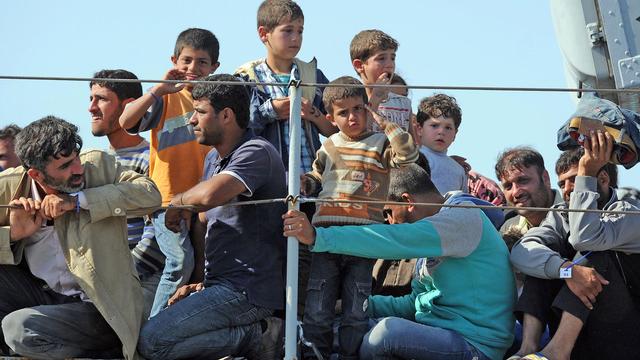 Immigrants recueillis à bord du "Chimera", bateau militaire italien, débarquants à Pozzalo le 30 juin 2014. [AFP - Giovanni Isolino]