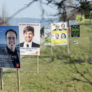 Des affiches pour les élections cantonales au bord d'une route. [Keystone - Walter Bieri]