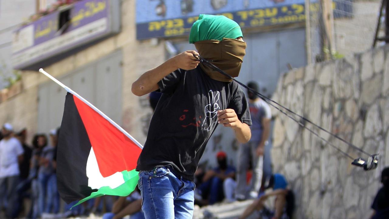 Un jeune palestinien affronte les soldats israéliens à coup de lance-pierre. [Muammar Awad / Anadolu Agency]