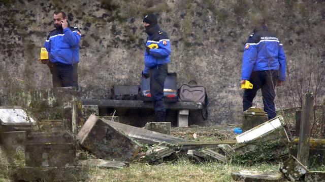 Gendarmes français enquêtant lundi dans le cimetière juif de Sarre-Union, dont la moitié des 400 sépultures ont été profanées. [Keystone/AP - Christian Lutz]