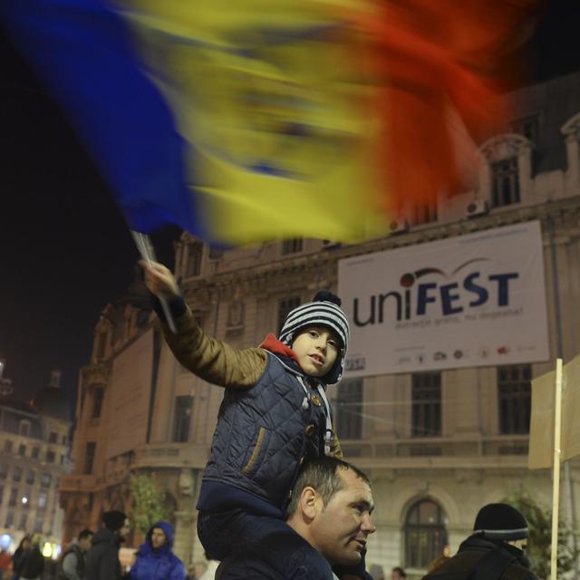 Un jeune protestataire brandit un drapeau roumain pendant les marches de protestation, Bucarest 8 novembre 2015. [NurPhoto / AFP - Artur Widak]