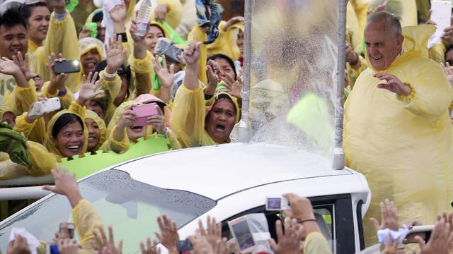 Le pape avait revêtu un poncho en plastique jaune par-dessus sa soutane blanche, comme les nombreux fidèles venus l'accueillir. [Damir Sagolj]