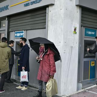 Les Grecs font la file devant les bancomats. [AFP - Louisa Gouliamaki]