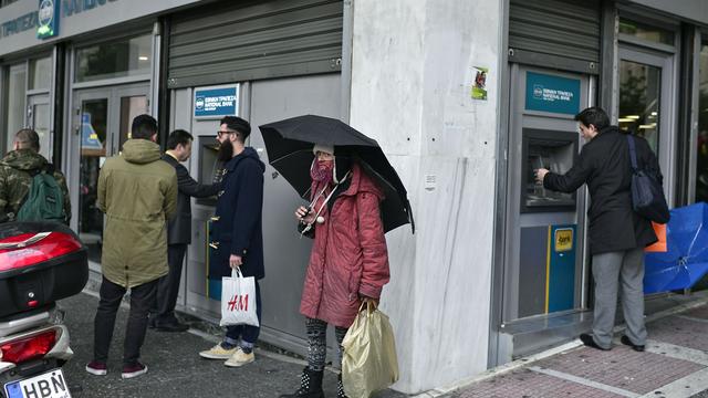 Les Grecs font la file devant les bancomats. [AFP - Louisa Gouliamaki]