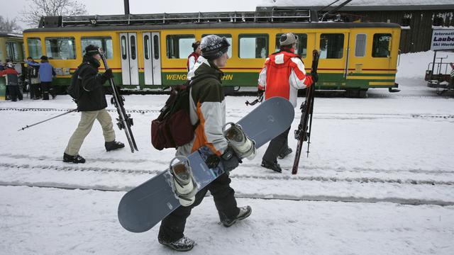 Des amateurs de glisse à la gare de Wengen, dans le canton de Berne. [Martin Ruetschi]