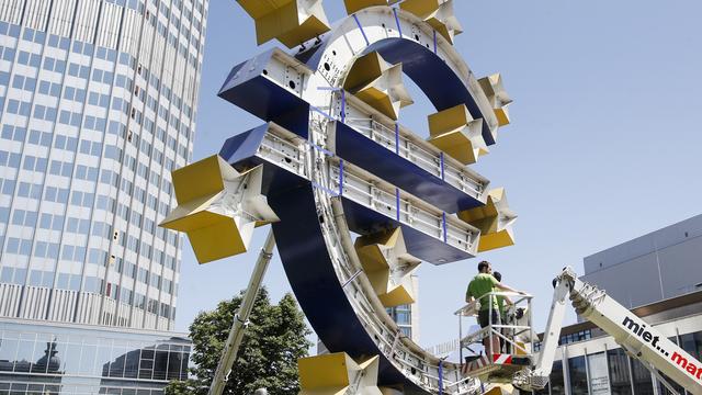 Travaux de rénovation sur la sculpture représentant l'Euro, devant l'ancienne Banque Centrale Européenne à Francfort, en juillet 2015.